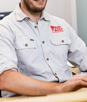 Close up of Red Bolt Engineering logo embroidered on team members shirt